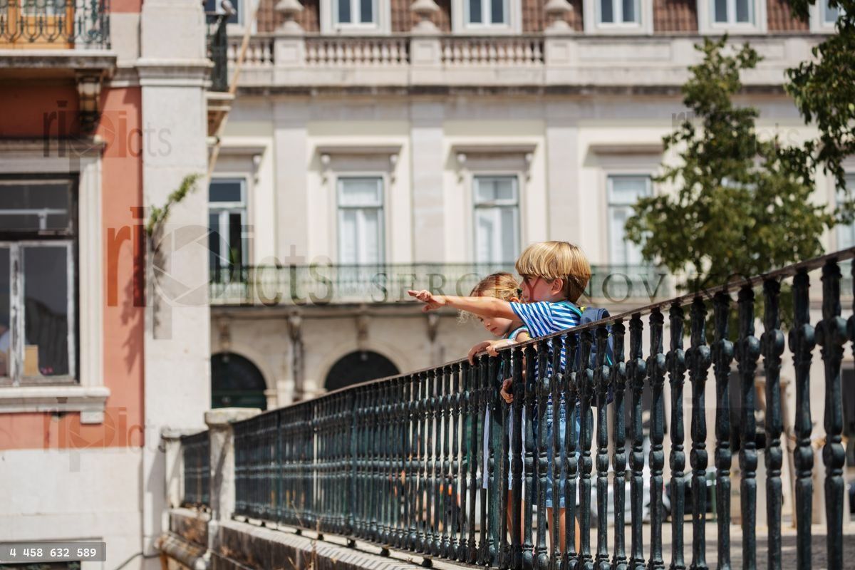 Young travelers at Lisbon viewpoint pointing with fingers