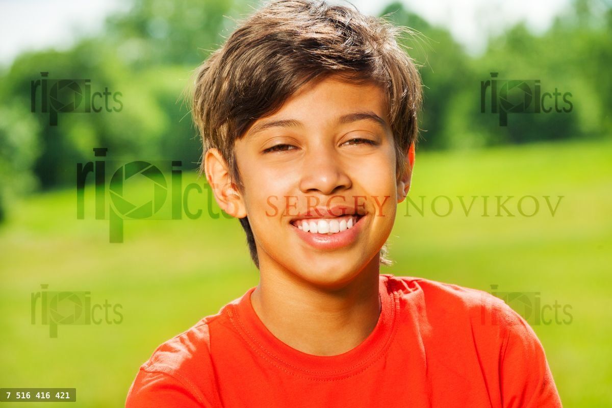 Brunet smiling boy in red T shirt portrait