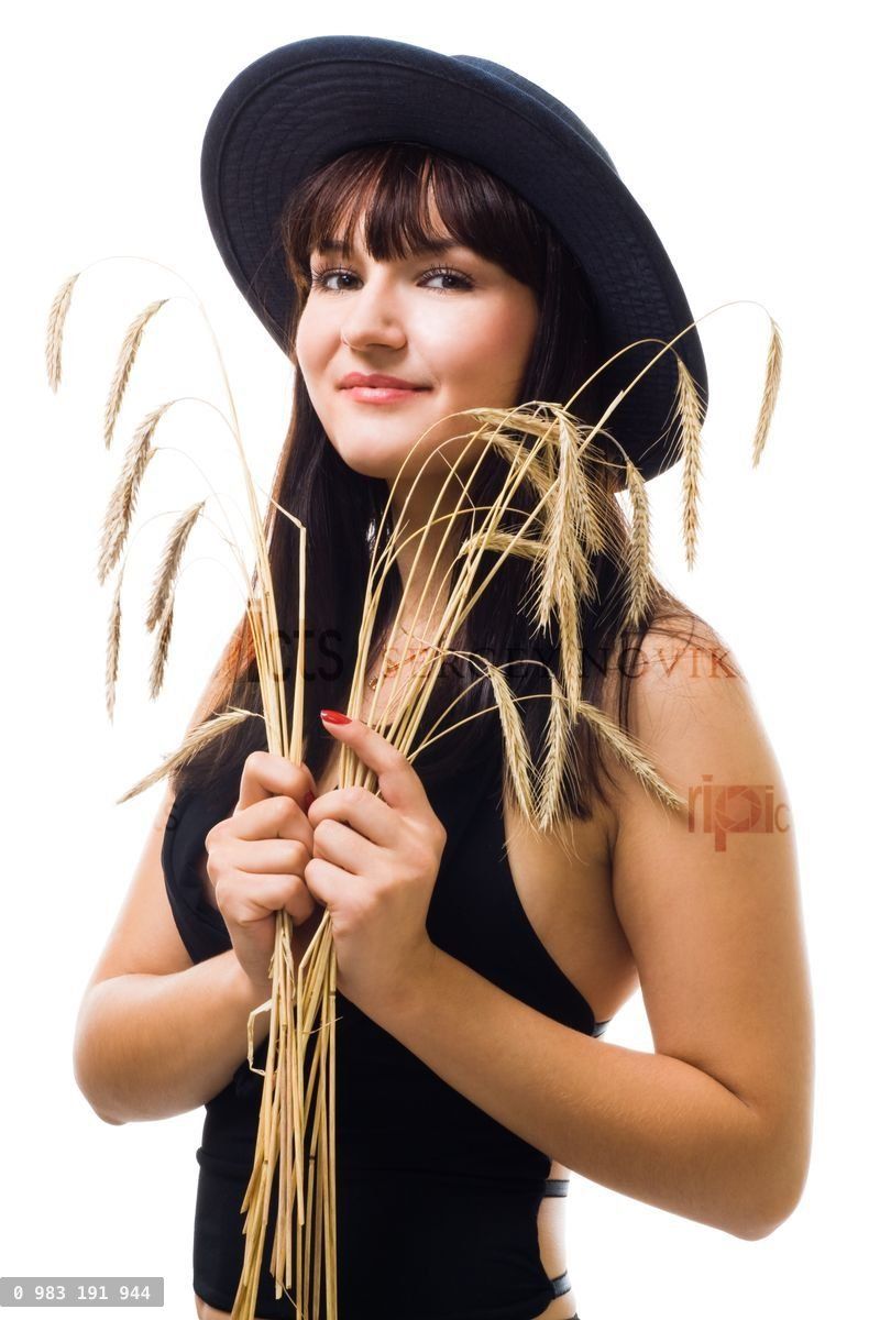 woman with bunch of wheat in blue hat smile