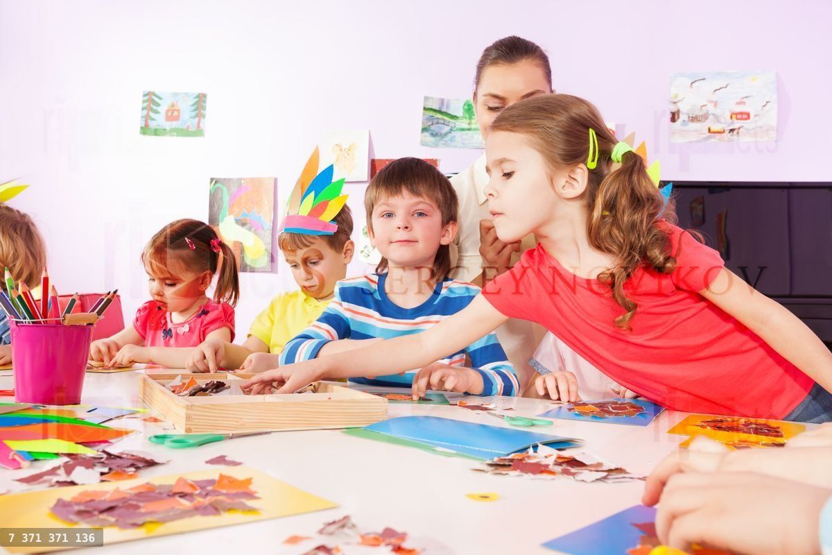 Une fille prend du papier pour faire une image en classe