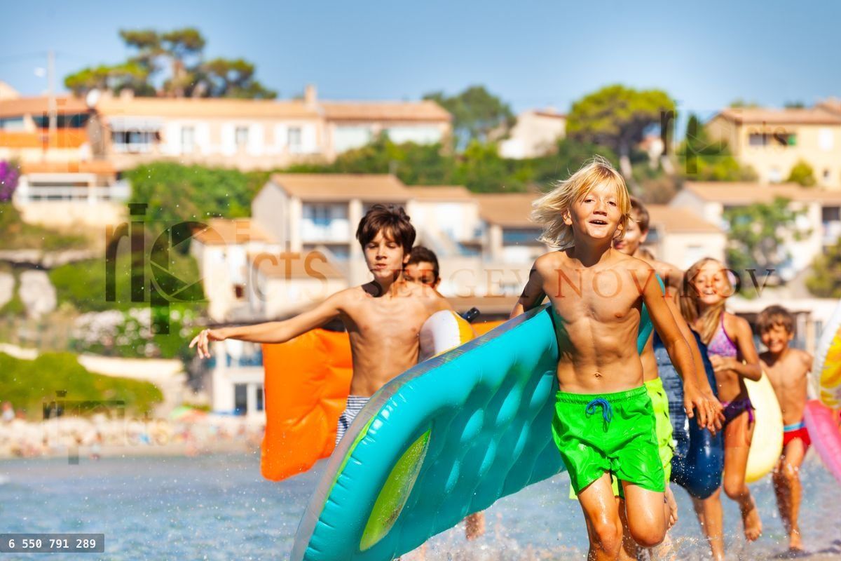 Happy boy running along the beach with his friends