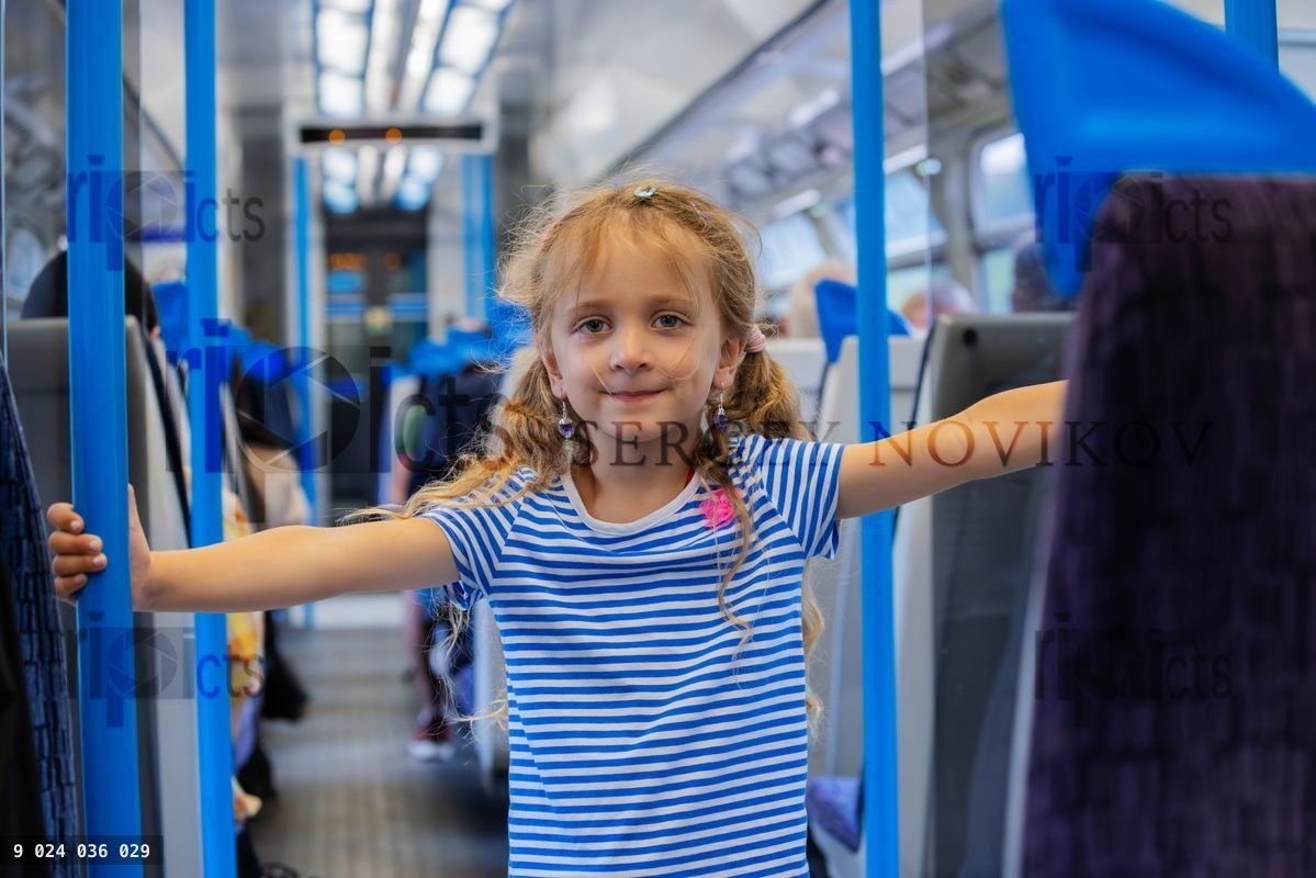 Young girl stand in passenger car, enjoy a train ride joyfully