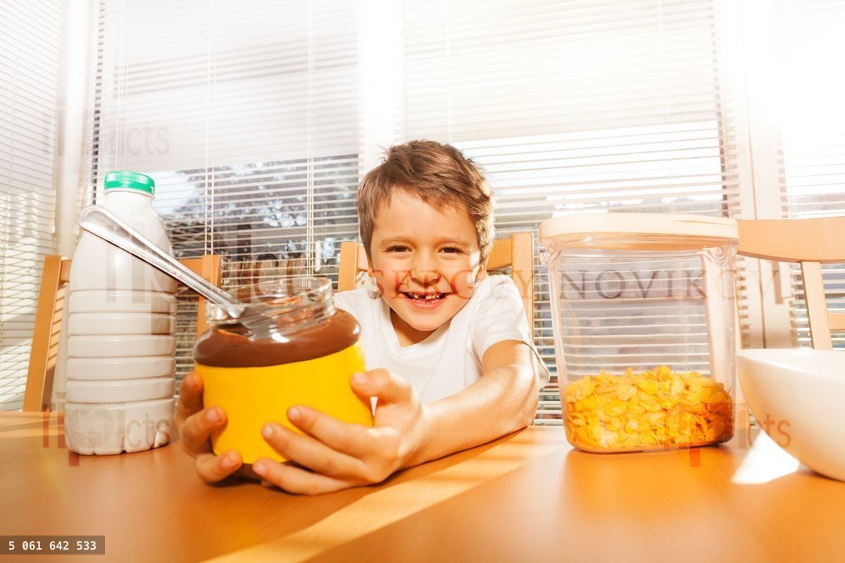 Happy boy holding glass can with chocolate spread