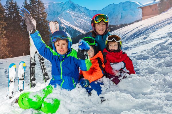 Family on ski vacation sit together in the snow over Mont Blanc