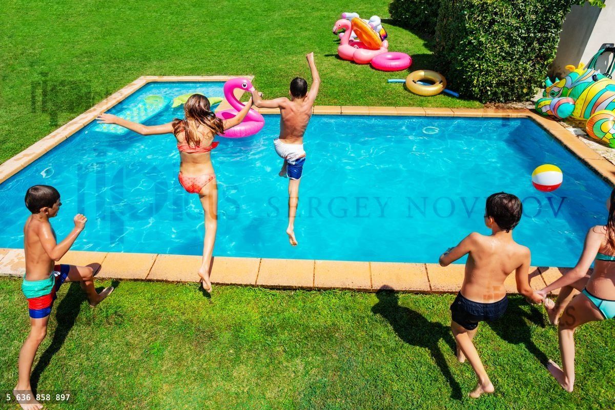 Young kids jump into the swimming pool together