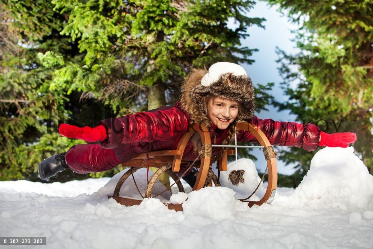 Cute beautiful girl having fun on snow sledge