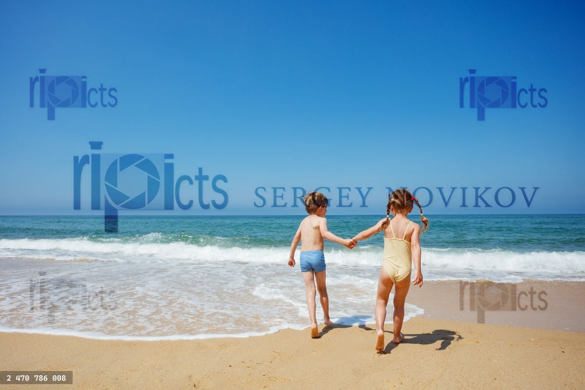 Young friends laughing and running on the sea shore, hold hands