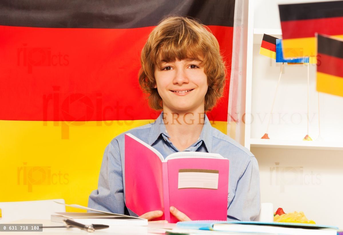 Boy with book and the colors of German flag behind