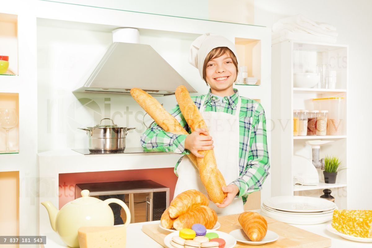 Young baker with fresh bakery food at the kitchen