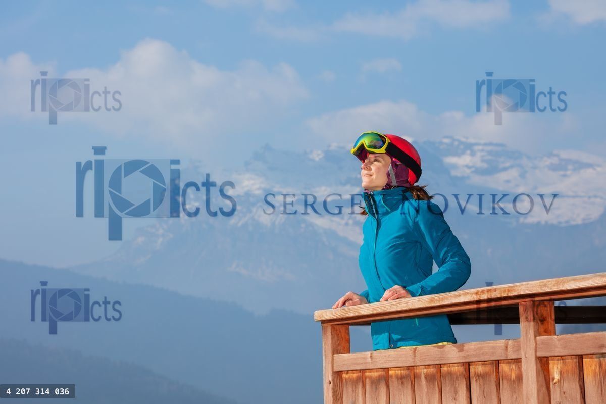 Woman skier enjoys mountain panorama in Alps