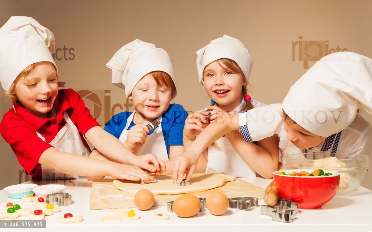 Four little bakers using cookie cutters
