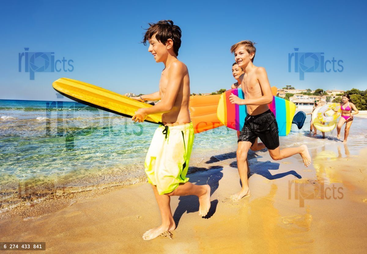 Boys with body boards preparing to ride the wave