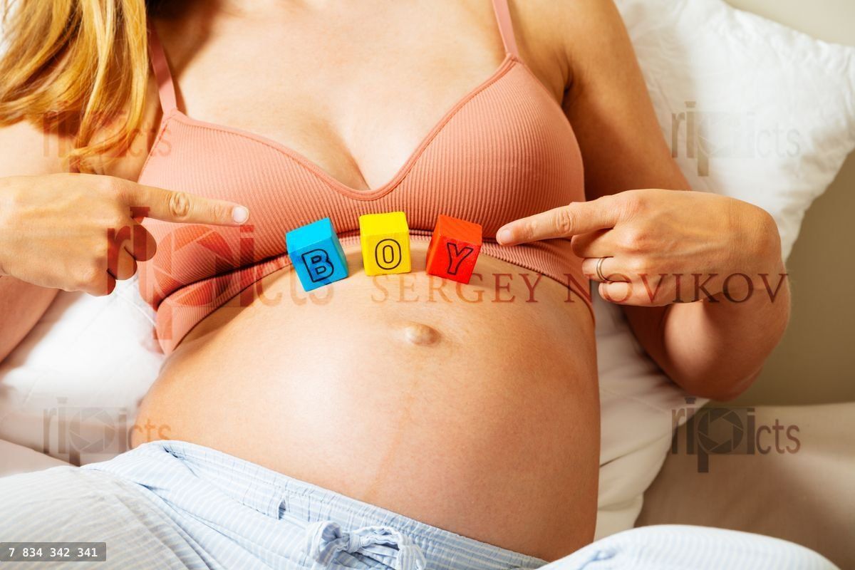 Woman points to boy word made of letters on belly
