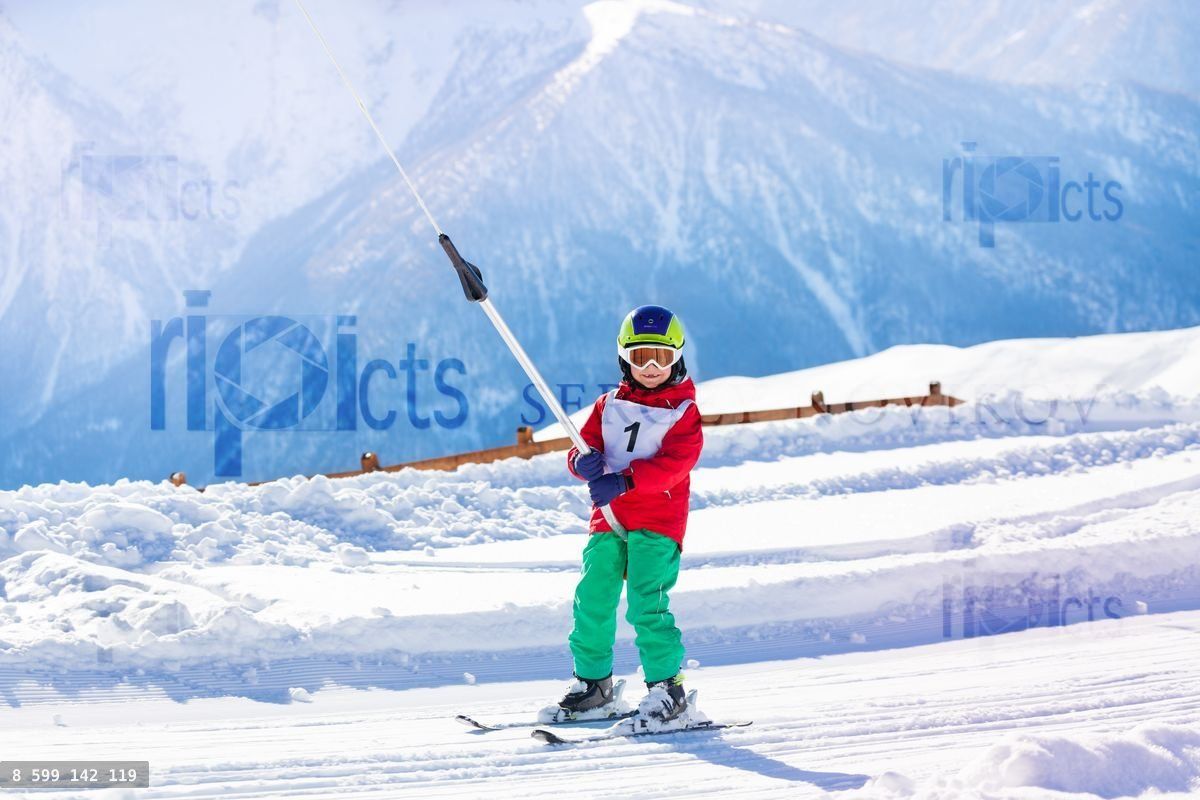 Young skier using a surface lift on the slope