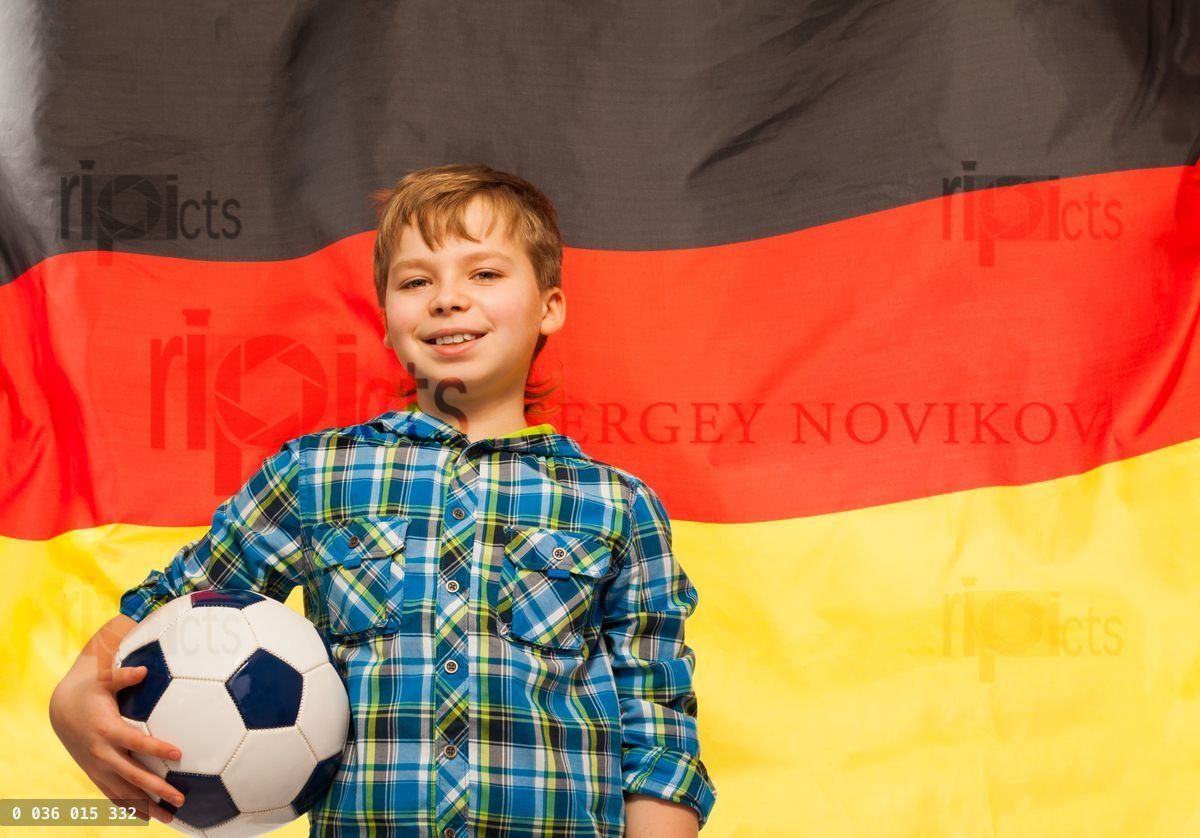 Young football fan with a ball against German flag