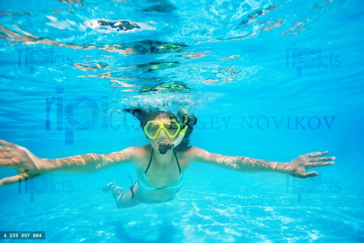 Woman wearing snorkeling mask swimming underwater