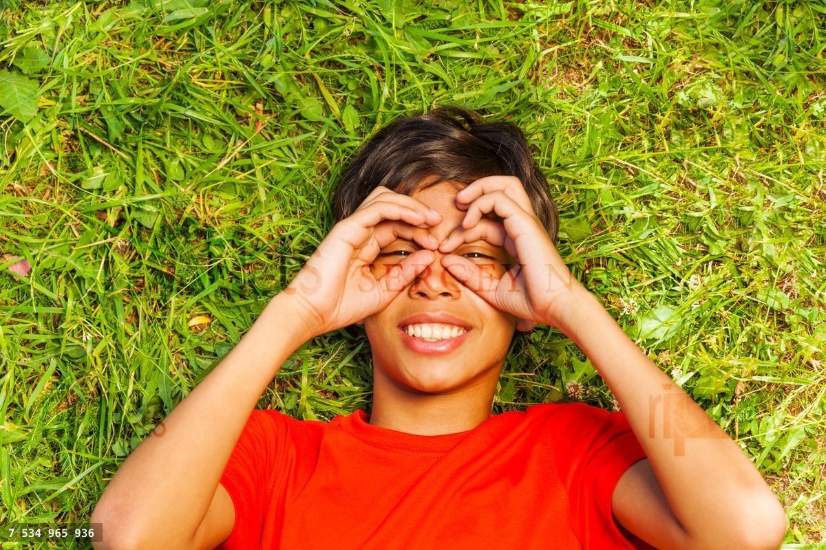 Funny boy with hands on face in glasses shape