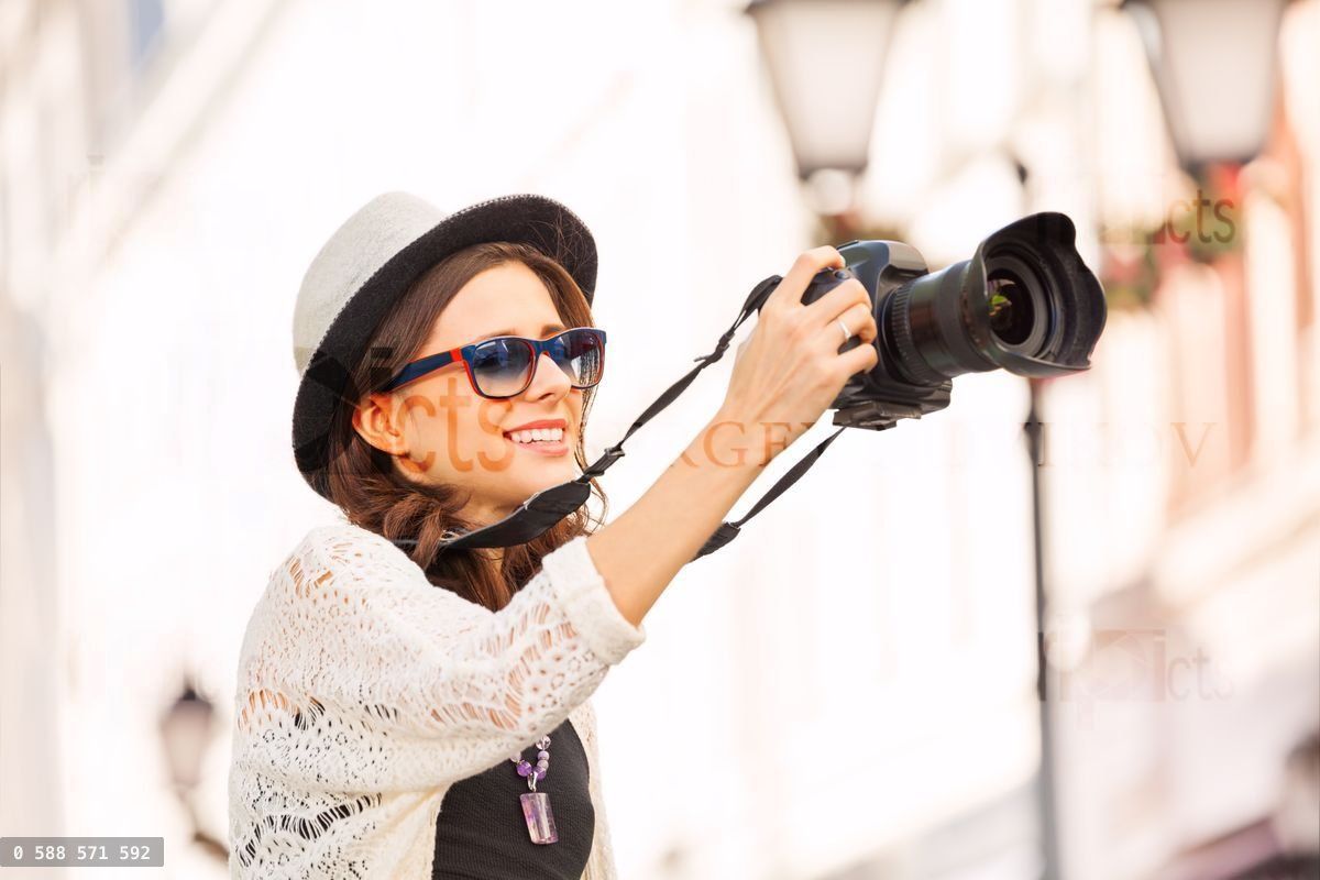 Woman wearing sunglasses shooting with camera