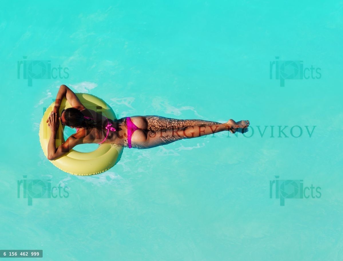 Woman swim on inflatable different color buoy