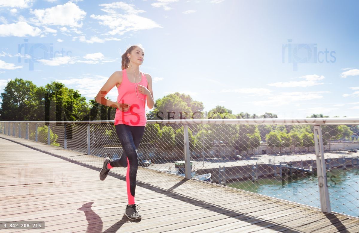 Woman running across a bridge during morning run