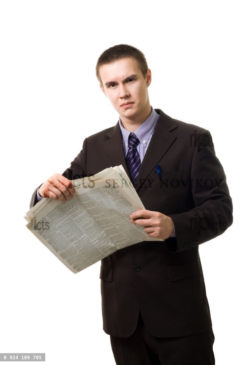 Young man reading newspaper standing