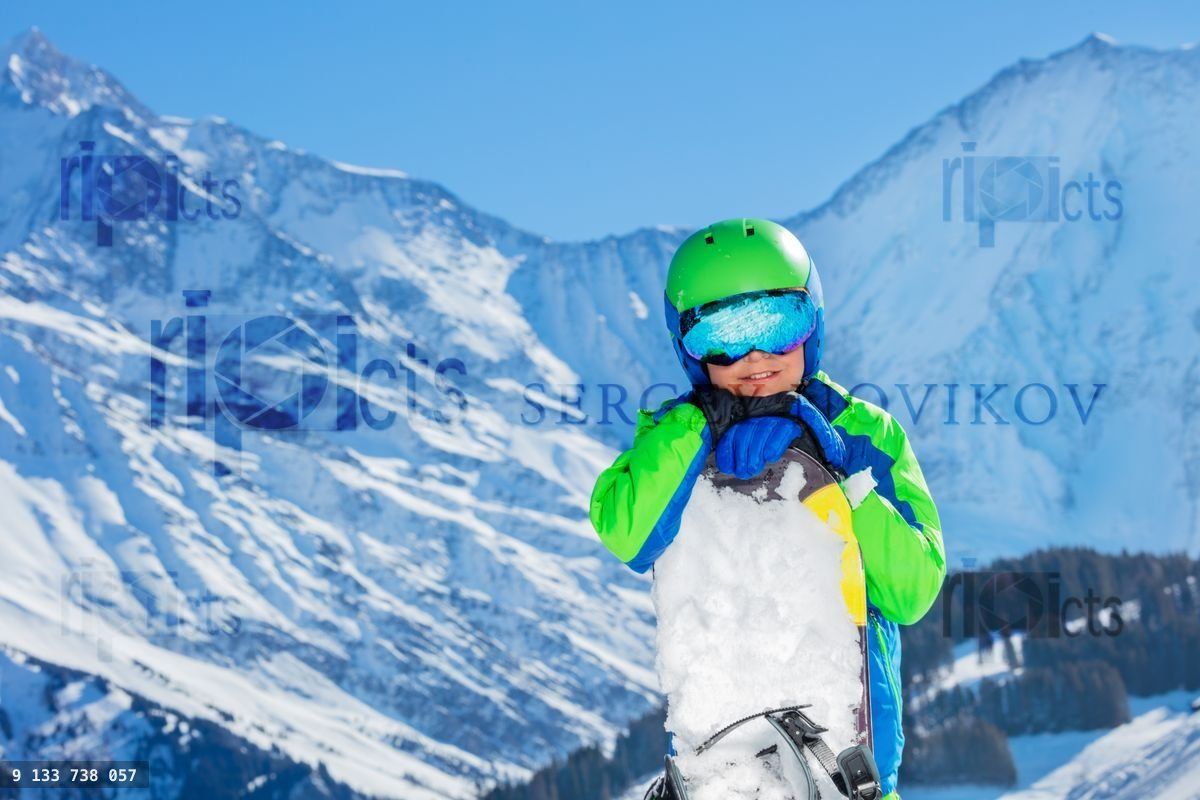 Close portrait of a young happy boy in helmet and ski mask
