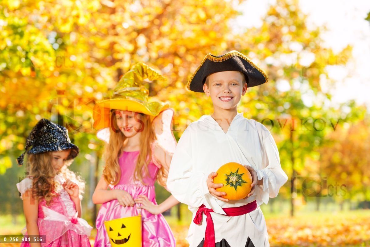 Friends in Halloween costumes hold small pumpkin