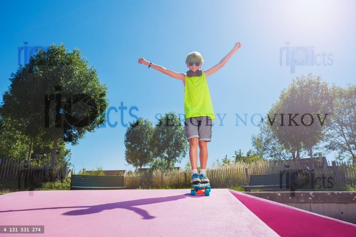 Young skater boy with green hair ride standing on skateboard