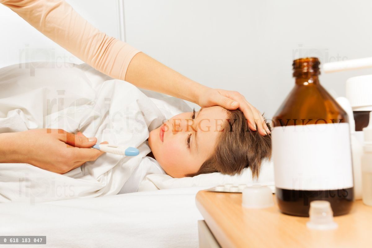 Woman caressing her son and checking temperature