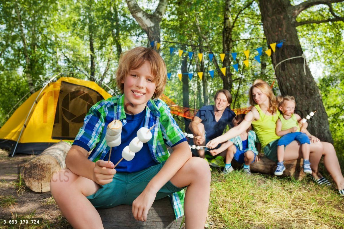 Happy boy with grilled marshmallow at the campsite