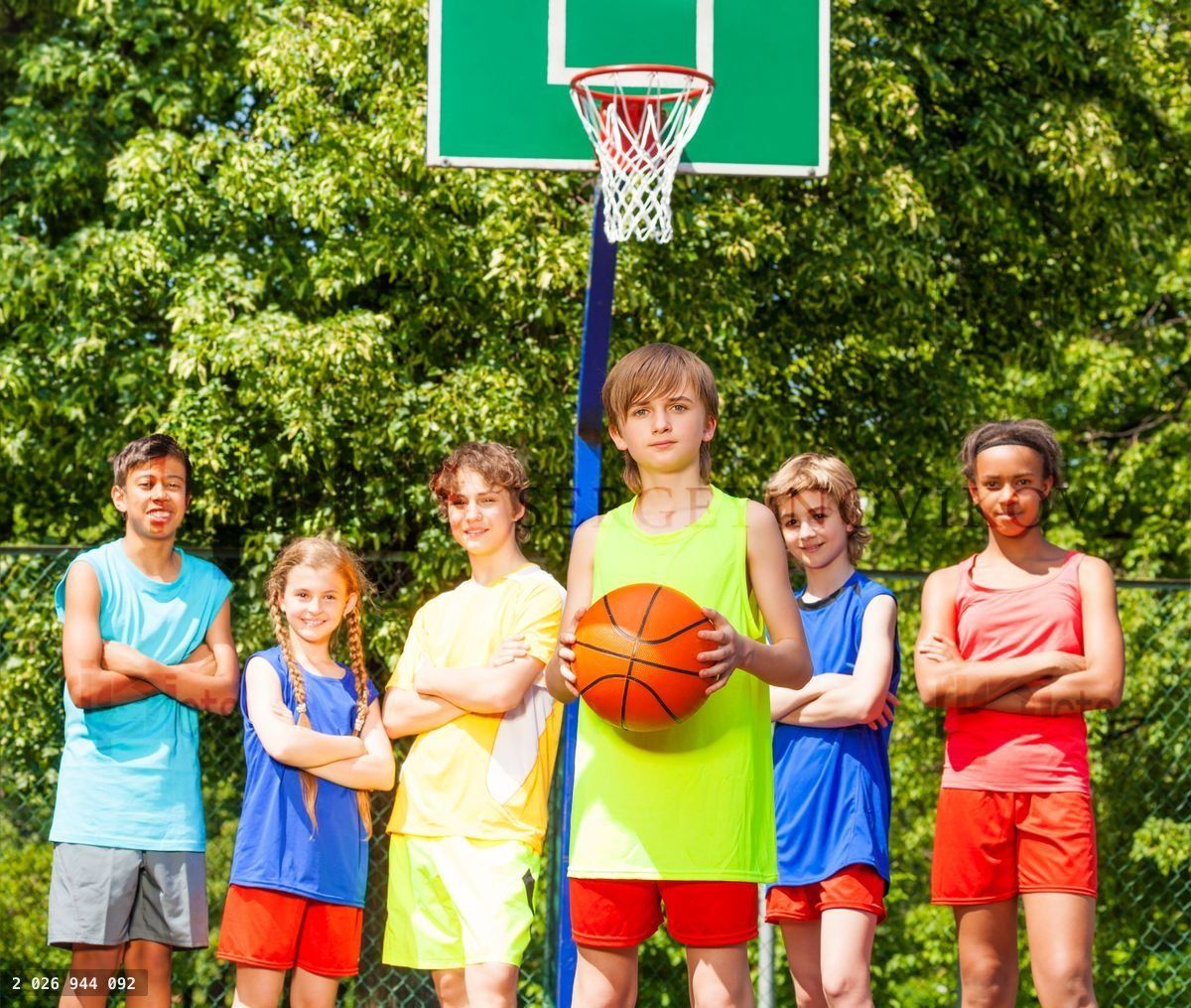 Boy with his team behind during basketball game