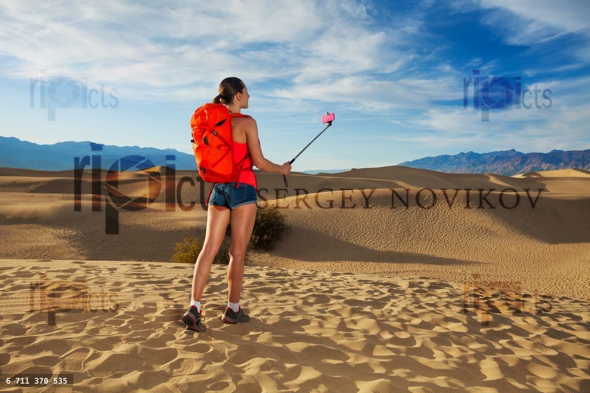 Woman with selfie stick take image in Death valley