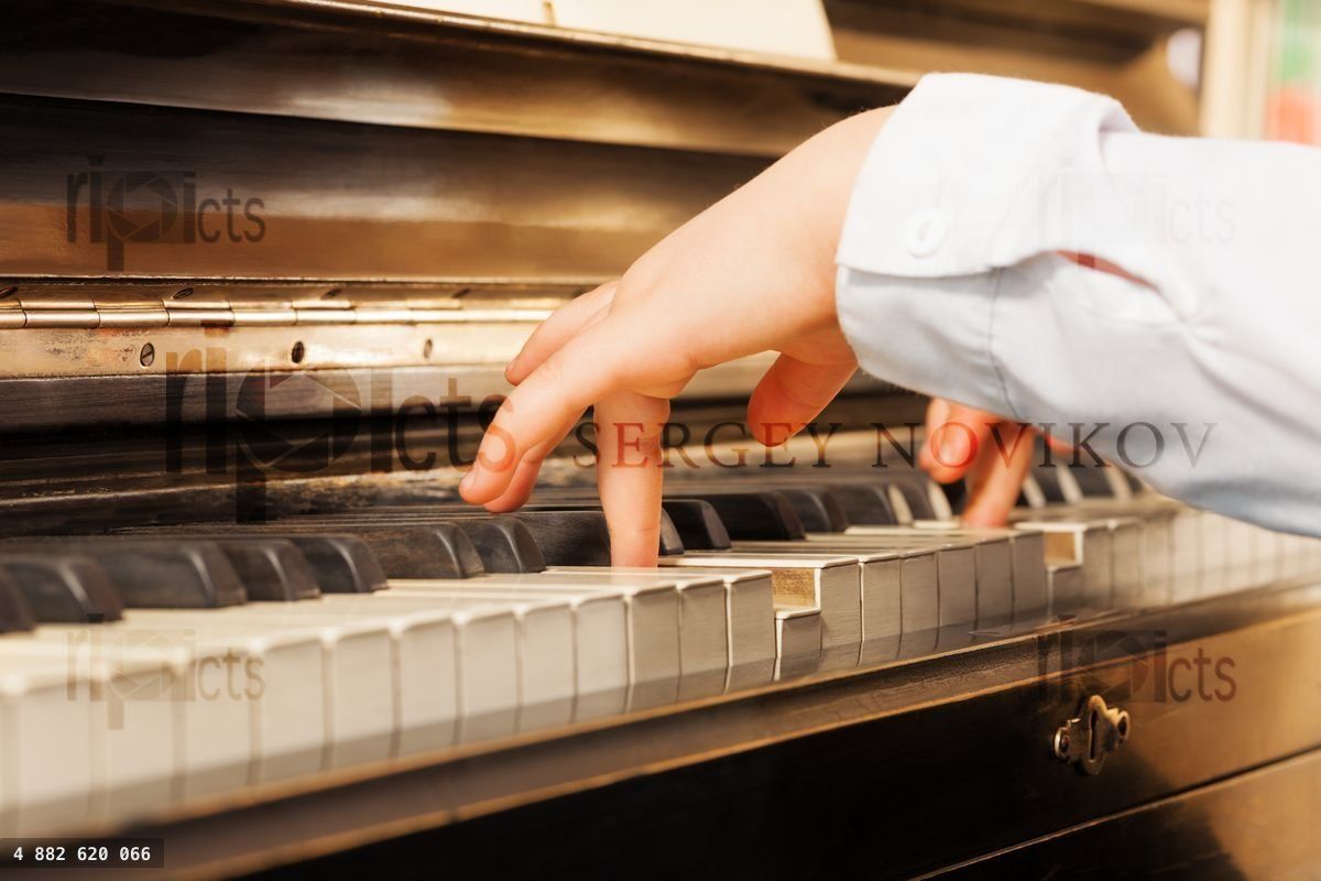 Close up view of child's hands playing on piano