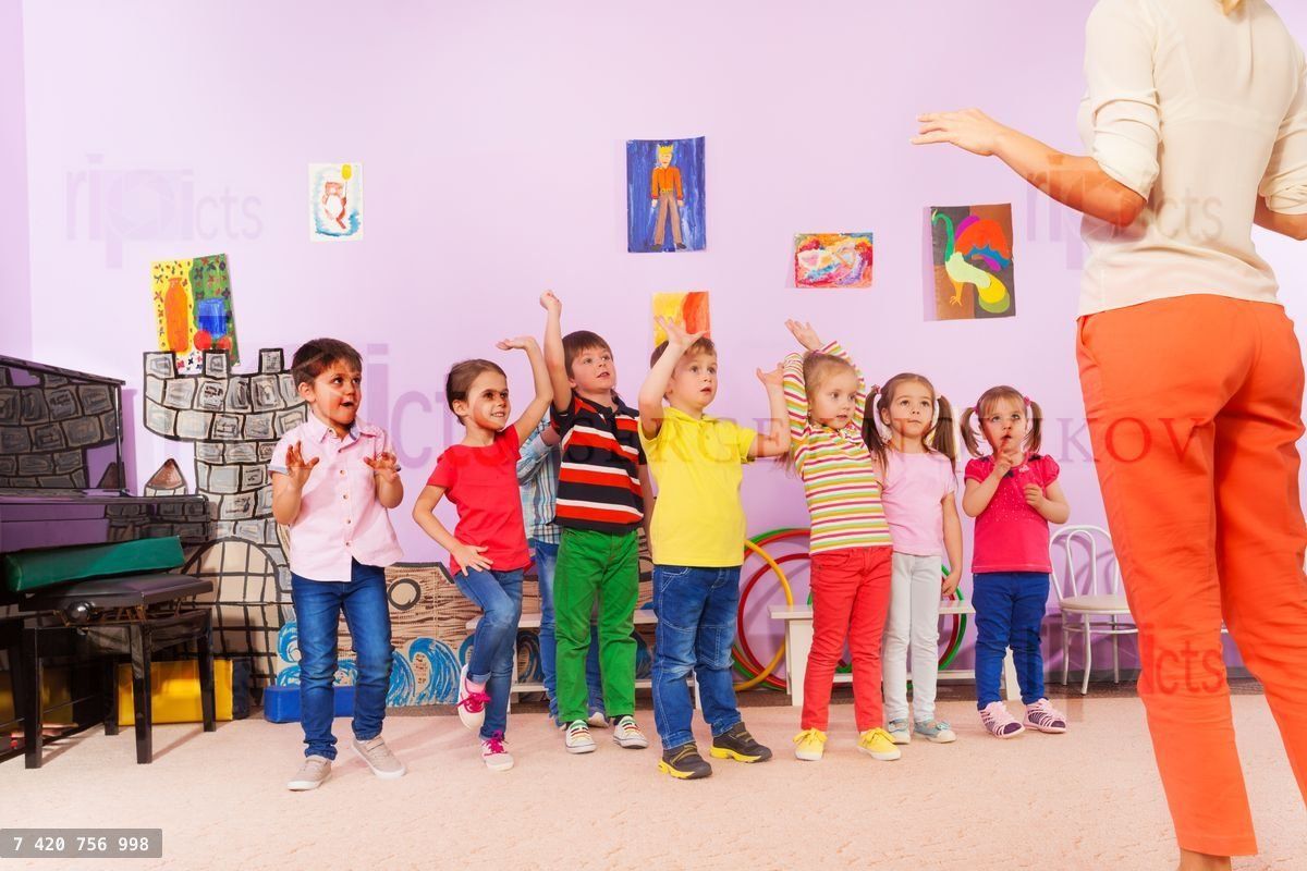 Group of kids repeating exercise after teacher
