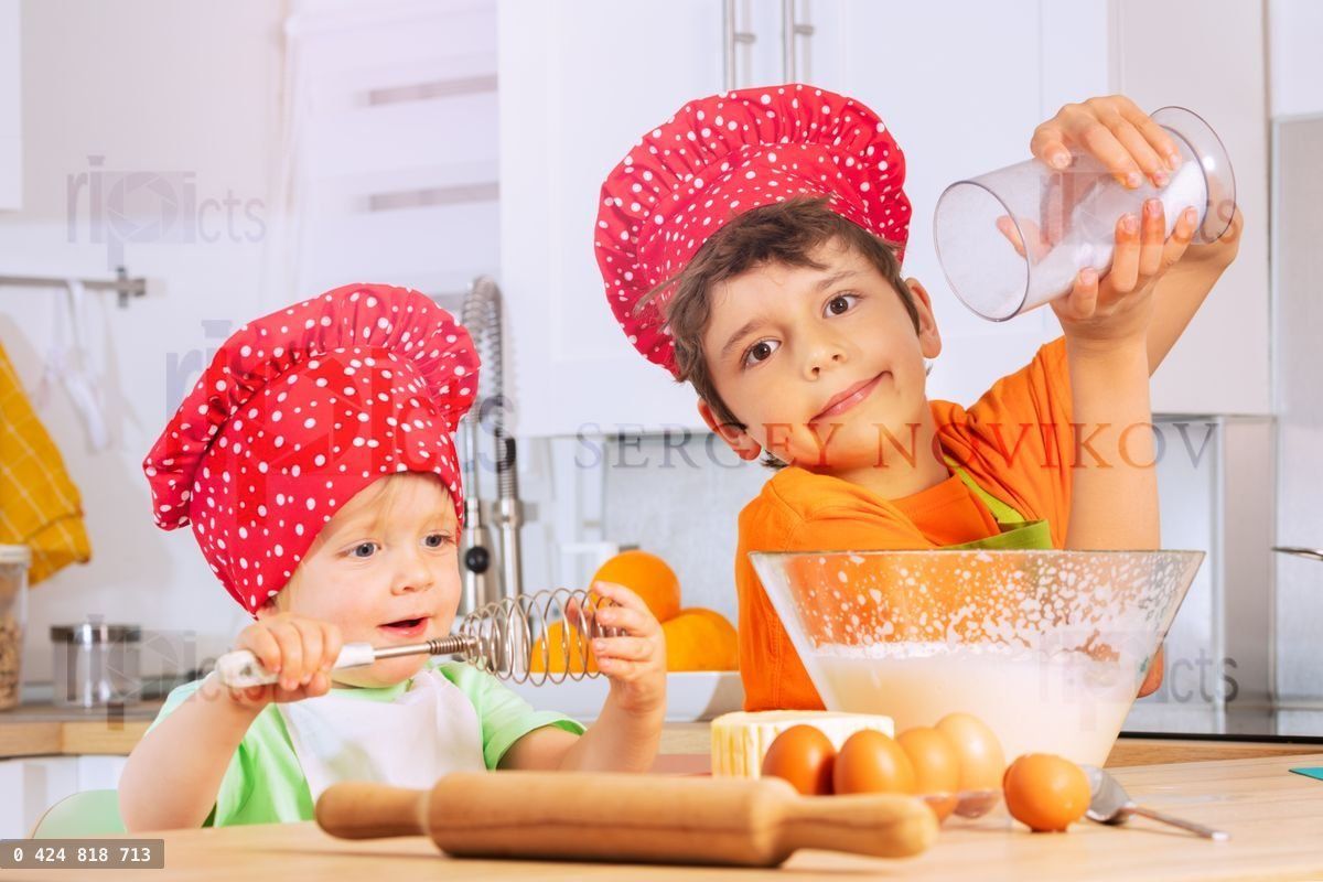 Boys cook cookies adding sugar to dough mix