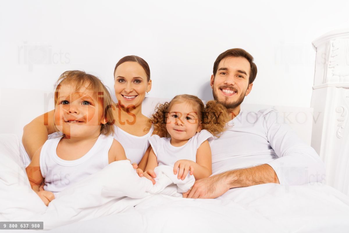 Close up of father, mother and two kids on bed