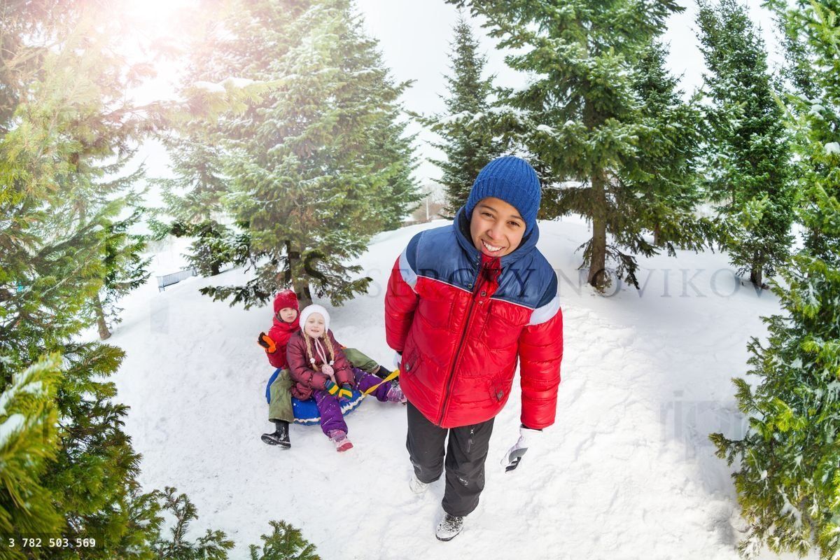 Friends sit on snow tube and other pulling them