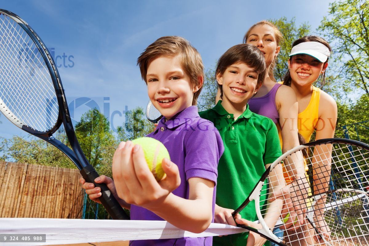 Family playing tennis holding rackets and ball