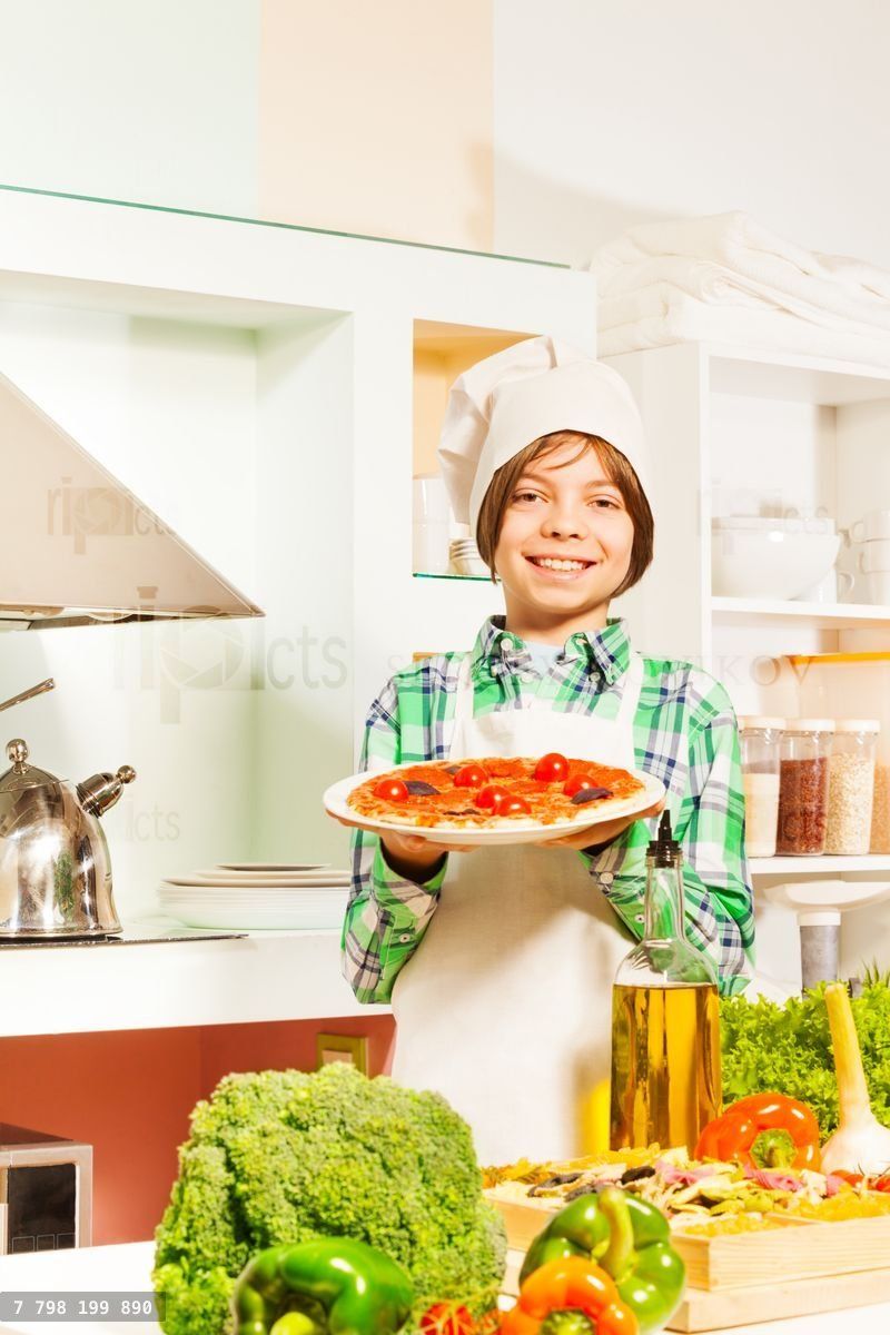 Young cook with tasty pizza in the kitchen