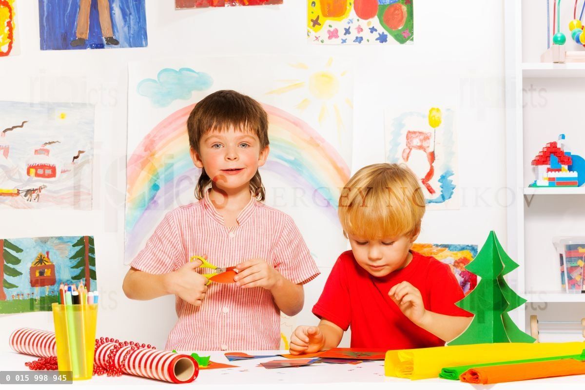 Boys making decorations and cutting carton