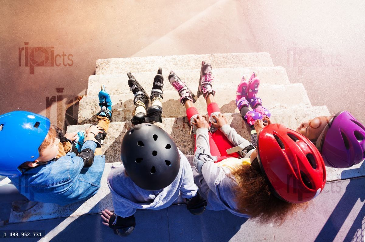 Young in line skaters sitting on stairs outdoors