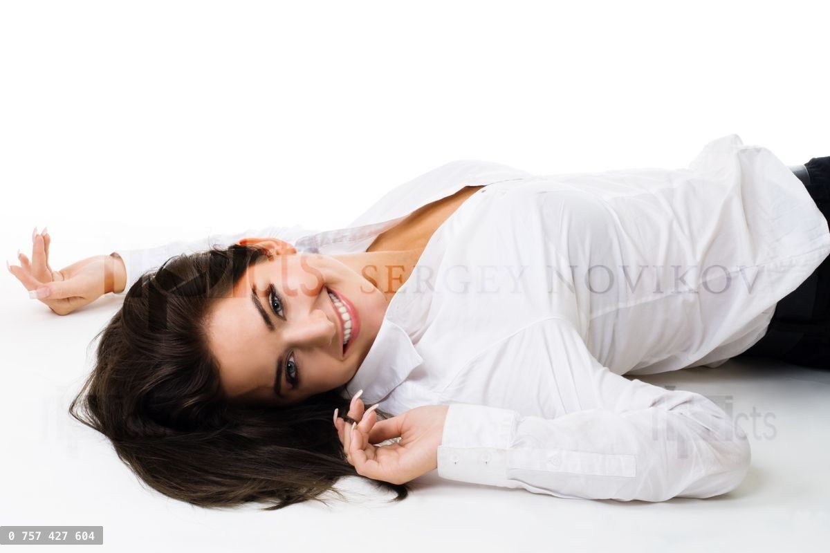 Young happy woman in white lay on the floor