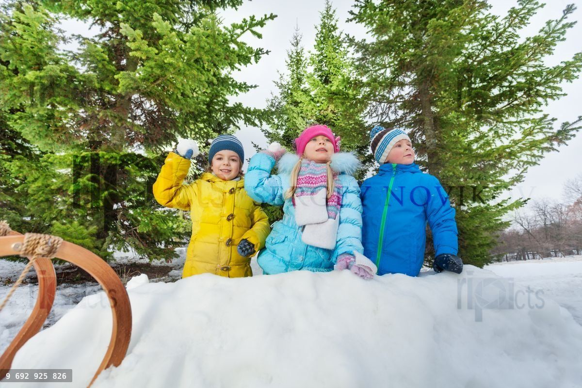Kids play snowball inside snow fortress in park
