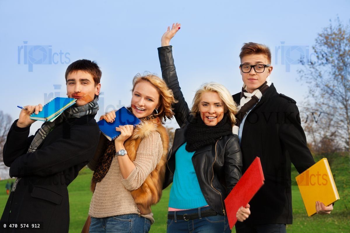Four students with books cheering