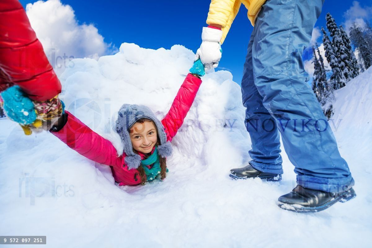 Friends helping girl to get out from the snow cave