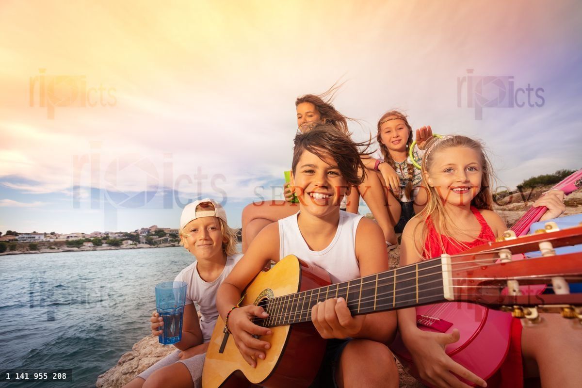 Young friends with guitar having fun outdoors