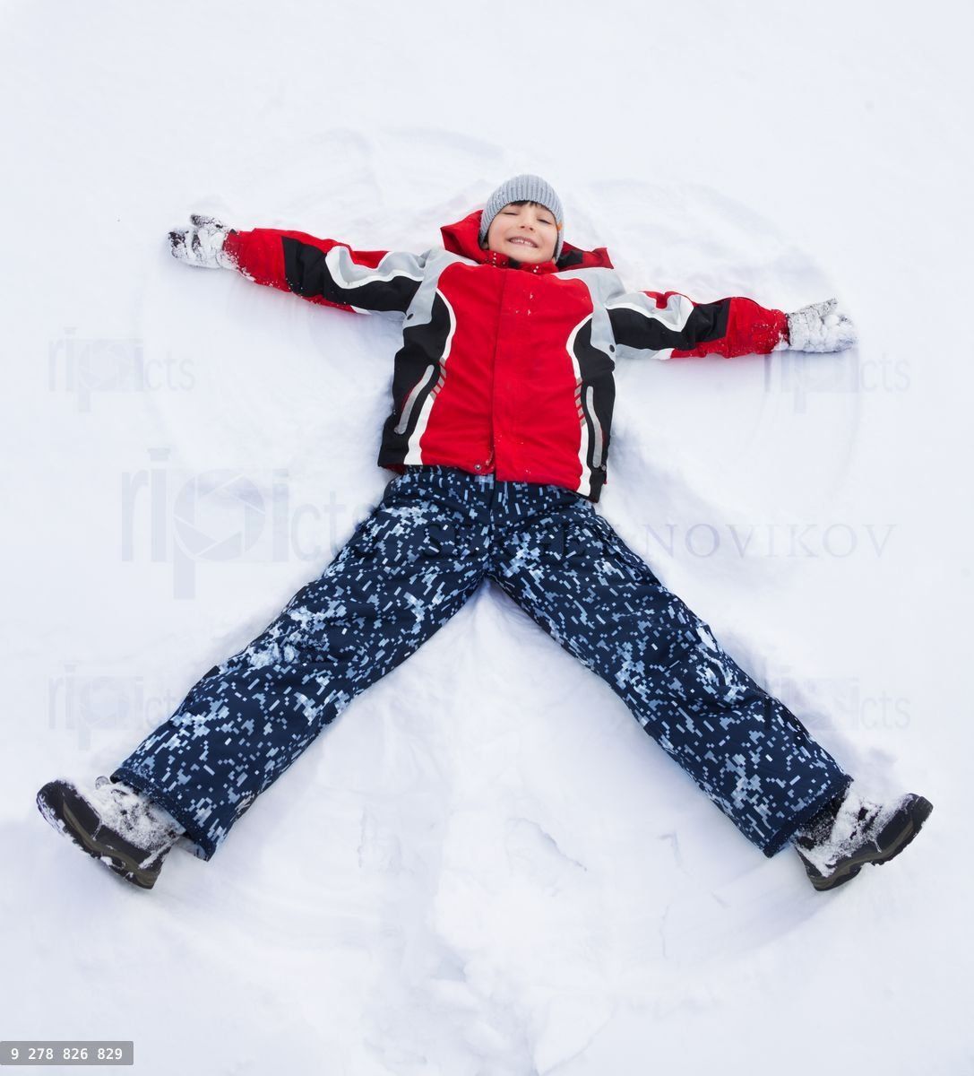 Boy laying in star shape in snow
