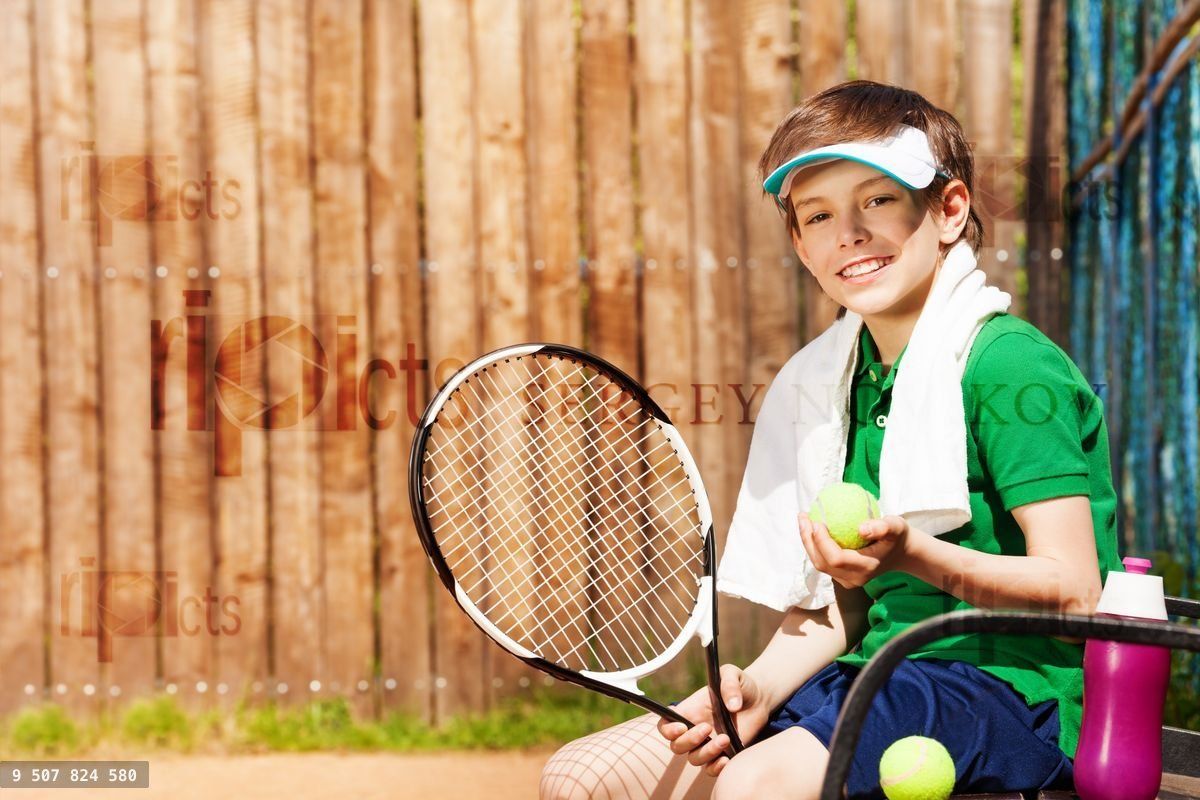 Young tennis player sitting on a bench after game