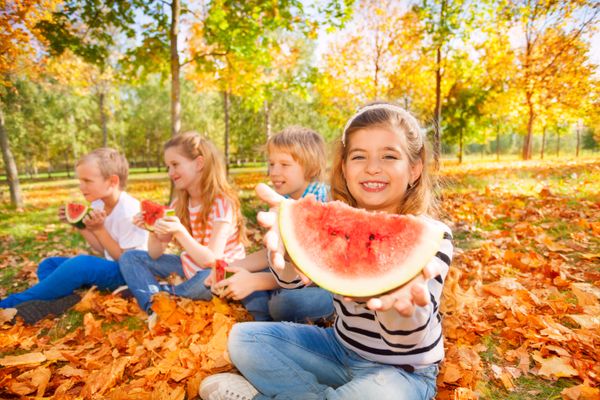 Happy kids holding watermelon and eating
