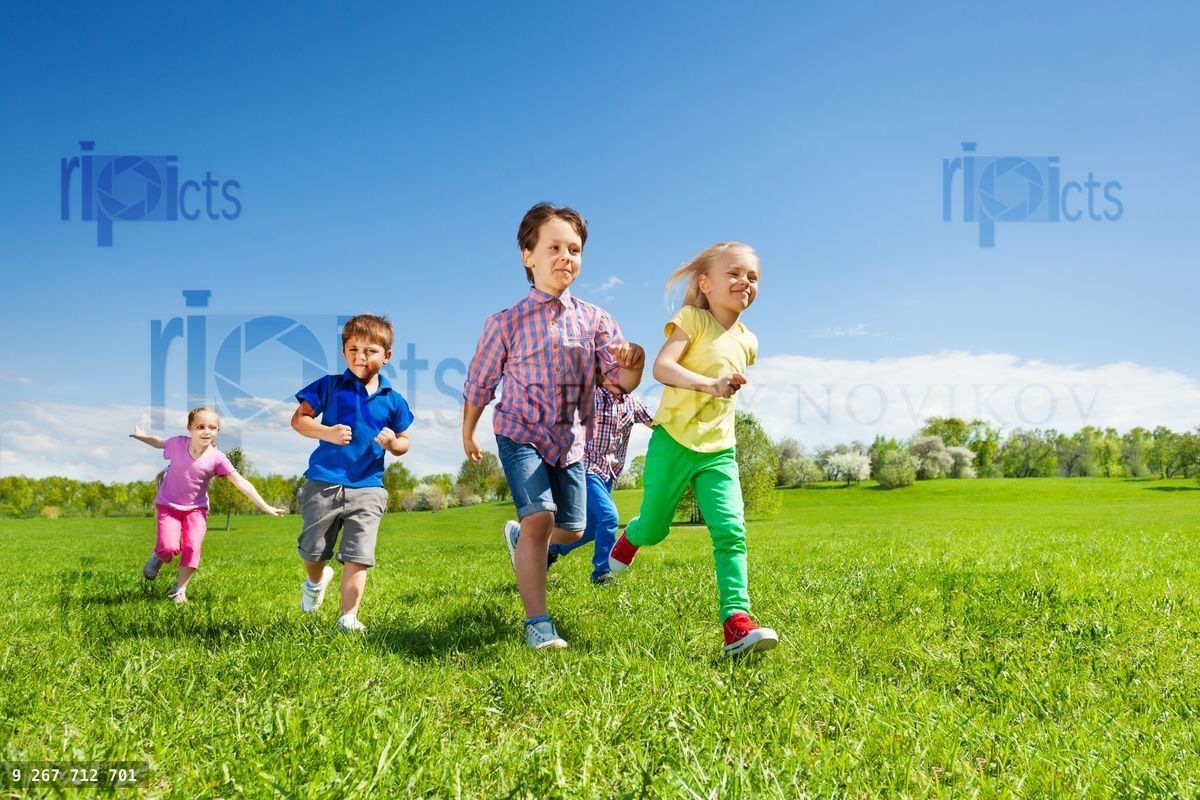 Happy group of children running in the green park